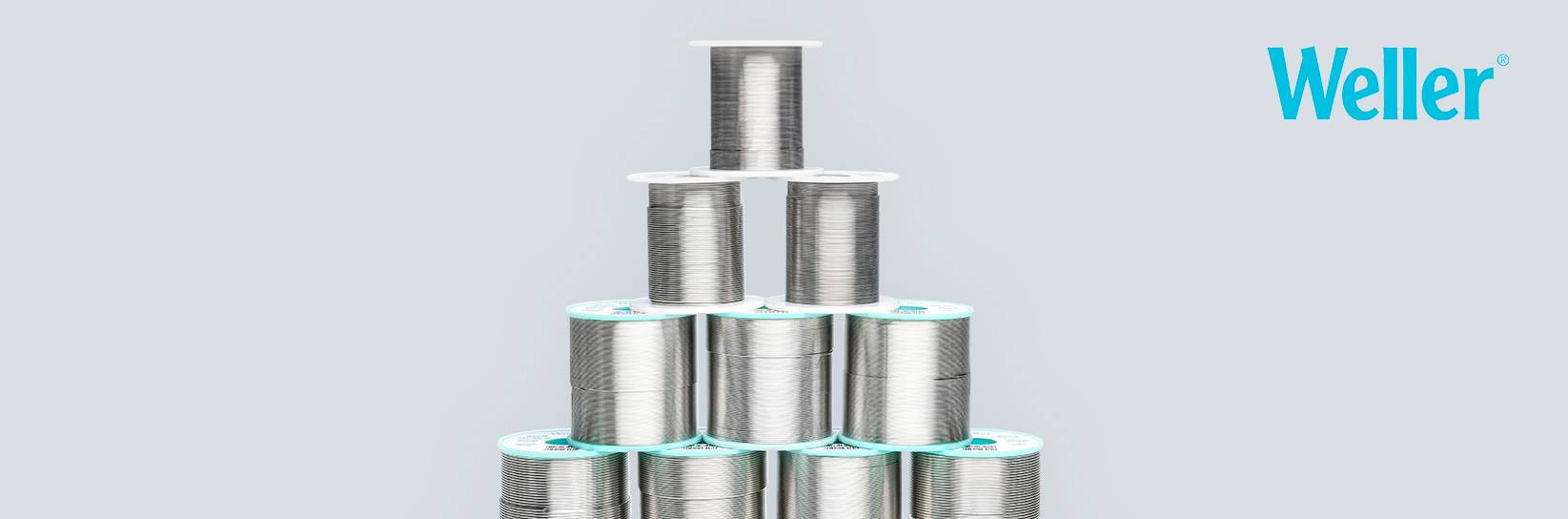 Pyramide aus Weller Lötdrahtspulen vor hellem Hintergrund.