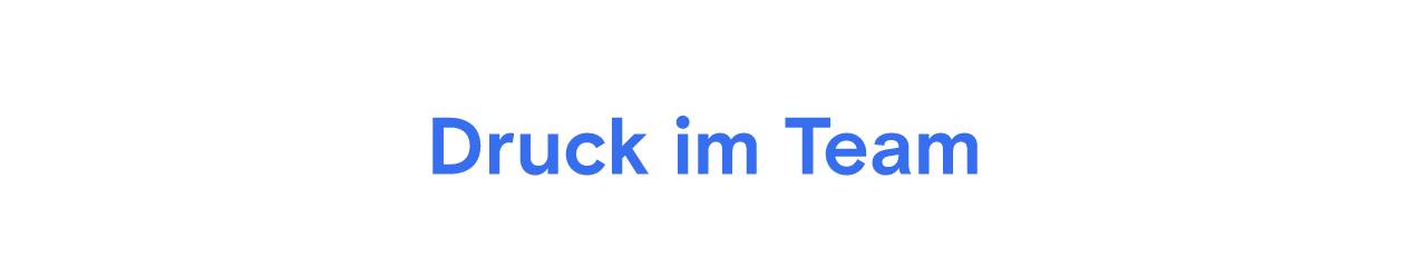 Blauer Text "Druck im Team" auf hellgrauem Hintergrund.