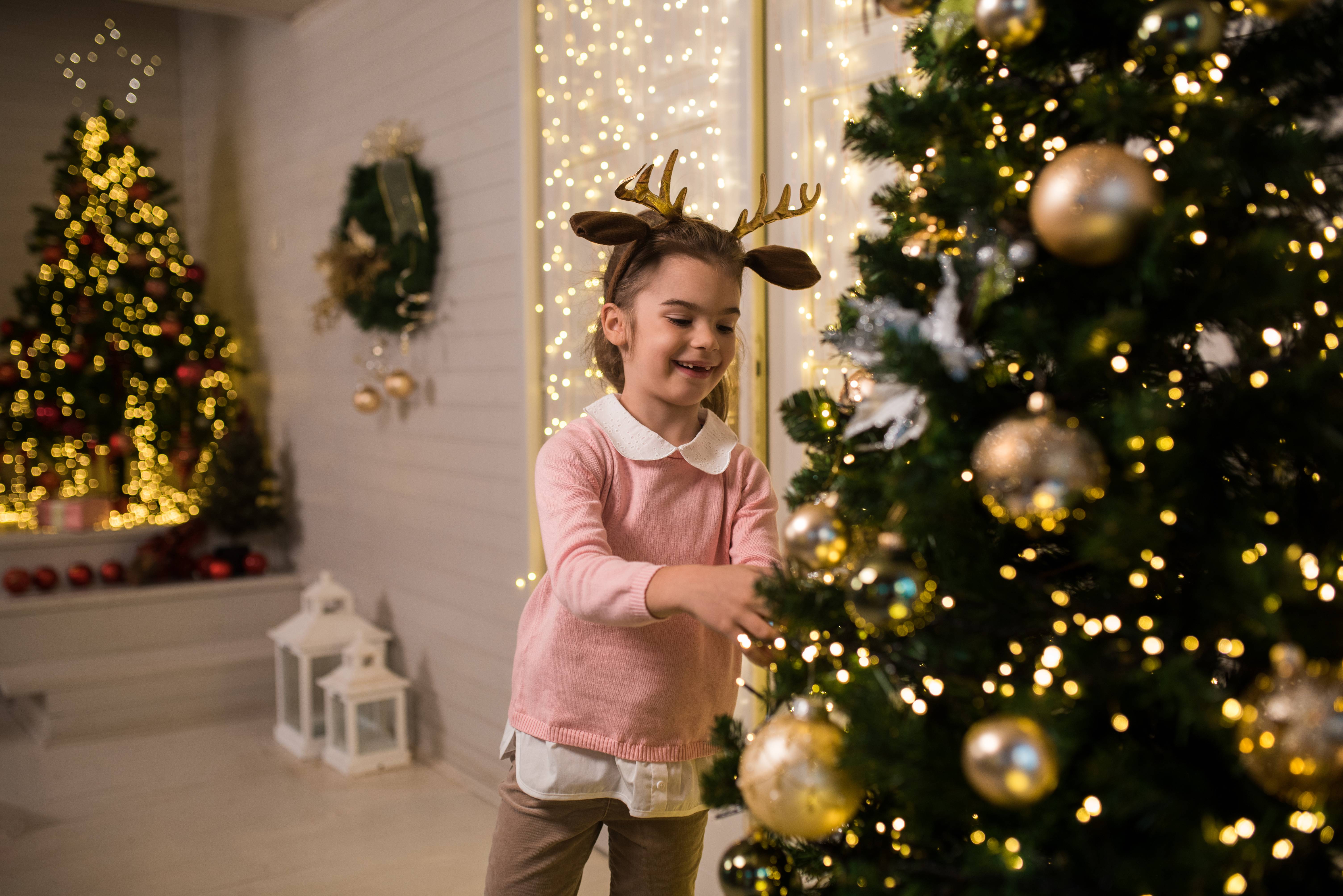Kind am beleuchteten Weihnachtsbaum