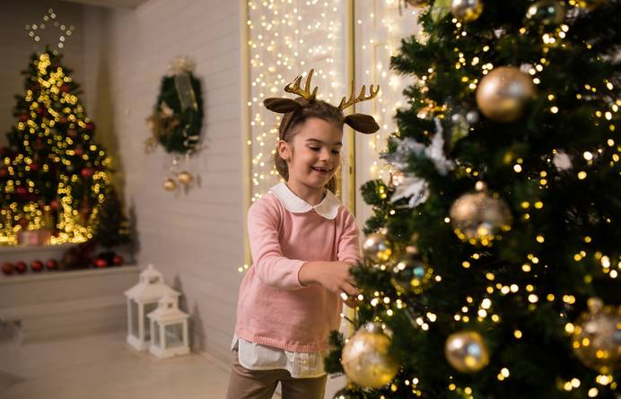 Kind am beleuchteten Weihnachtsbaum