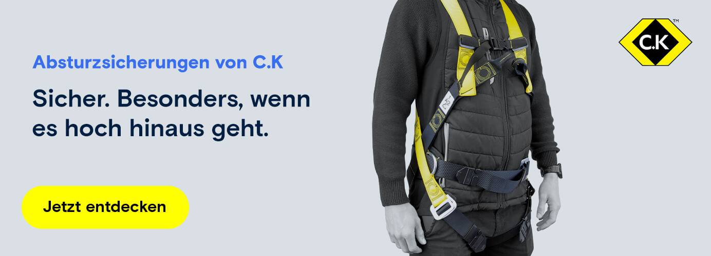 Person trägt C.K Absturzsicherung mit gelben Gurten für maximale Sicherheit bei Höhenarbeiten.