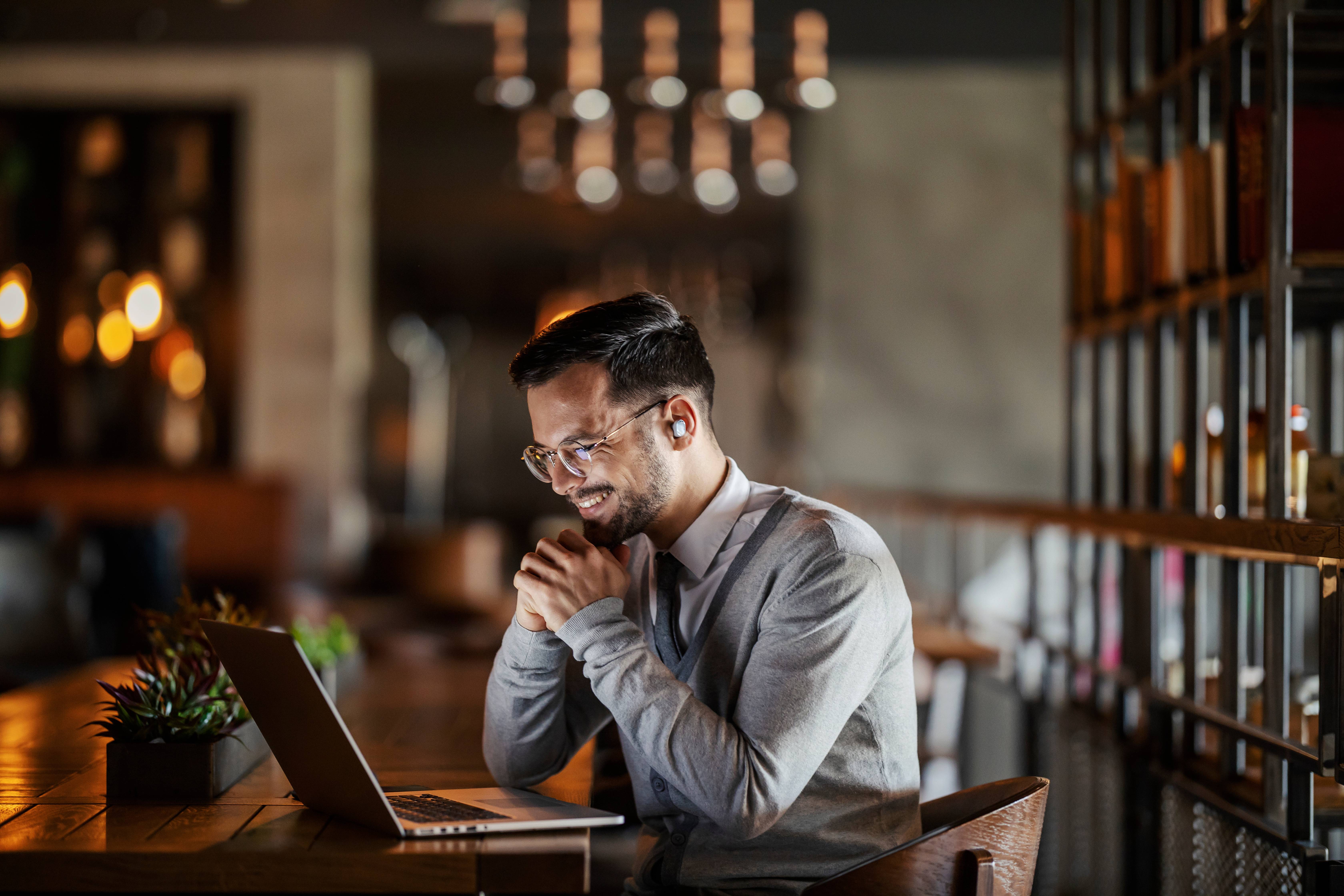 Auf diesem Bild sieht man einen Mann, der mit einem Laptop aus dem Home-Office arbeitest