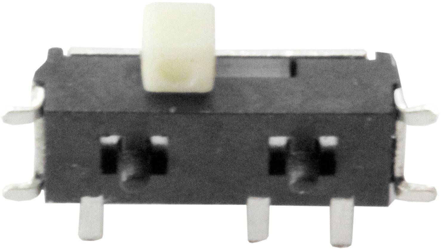 Malý černý páčkový přepínač se šesti kovovými svorkami, používaný pro ovládání elektrických obvodů.