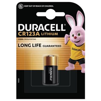 Duracell CR123A baterka z lithia v balení s růžovým vzorem tučňáka. Text 'Dlouhá životnost zaručena' a výstraha 'Uchovávejte mimo dosah dětí'.