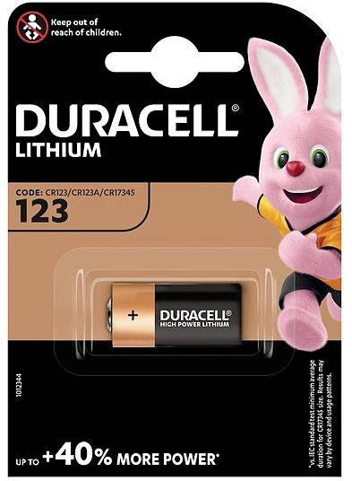 Balení lithiové baterie Duracell s baterií CR123 a růžovým zajíčkem ve sportovním oblečení, který drží baterii v ruce.