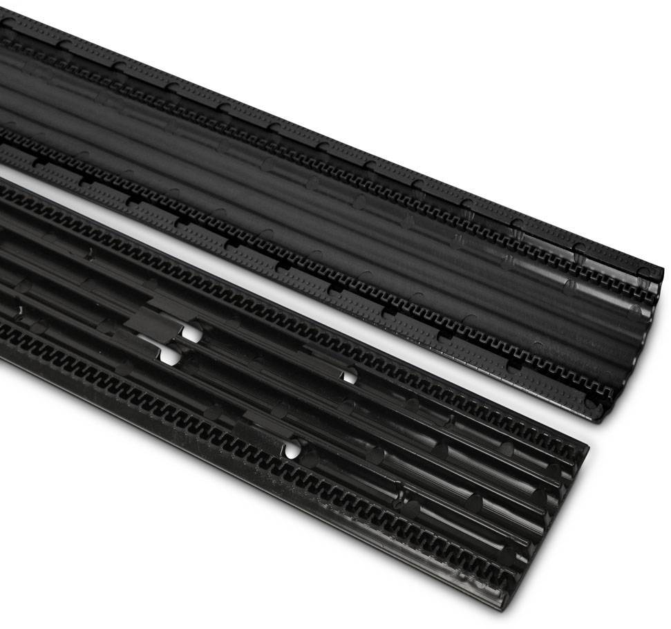 Dva černé plastové díly, pravděpodobně konstrukční komponenty, leží vedle sebe rovnoběžně.