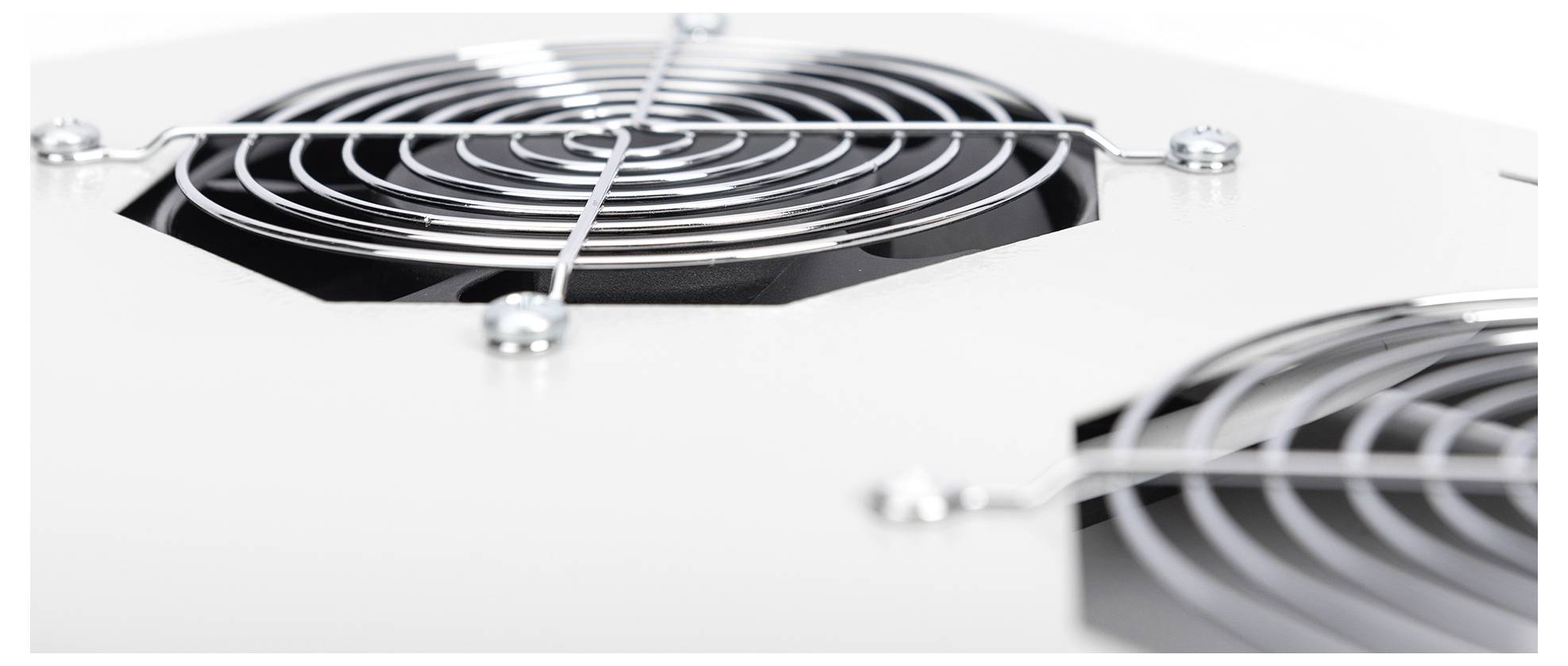Detailní záběr bílého kovového panelu se dvěma kruhovými ventilačními mřížkami a šrouby, což naznačuje část elektronického zařízení nebo domácího spotřebiče.