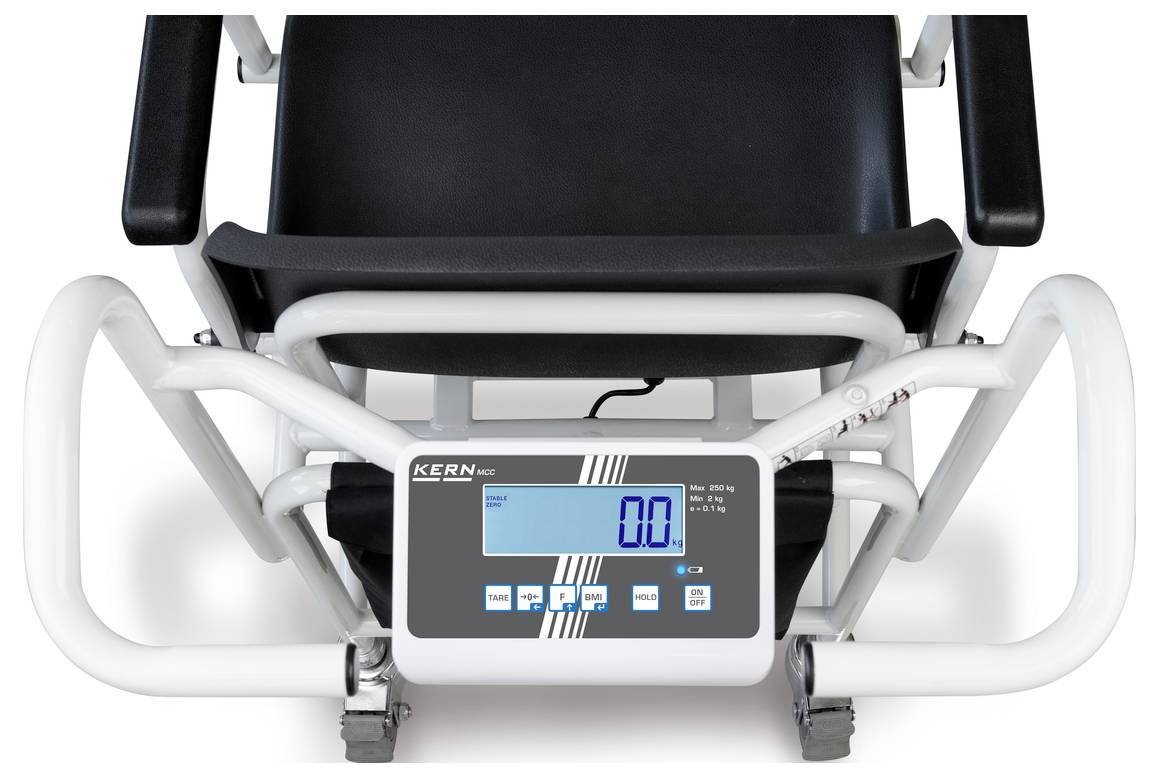Invalidní vozík s digitálním displejem ukazuje hmotnost 0,0 kg. Displej je umístěn na přední straně vozíku.