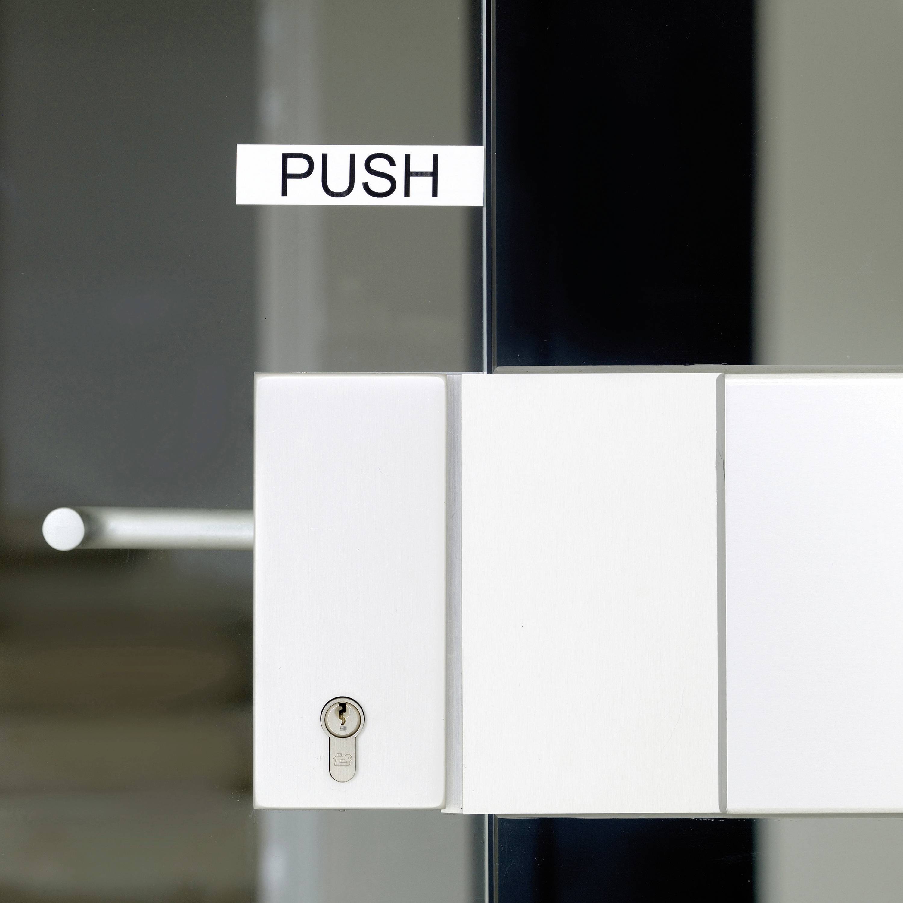 Zámek dveří s cedulkou "PUSH", která upozorňuje na nutnost zatlačení dveří.