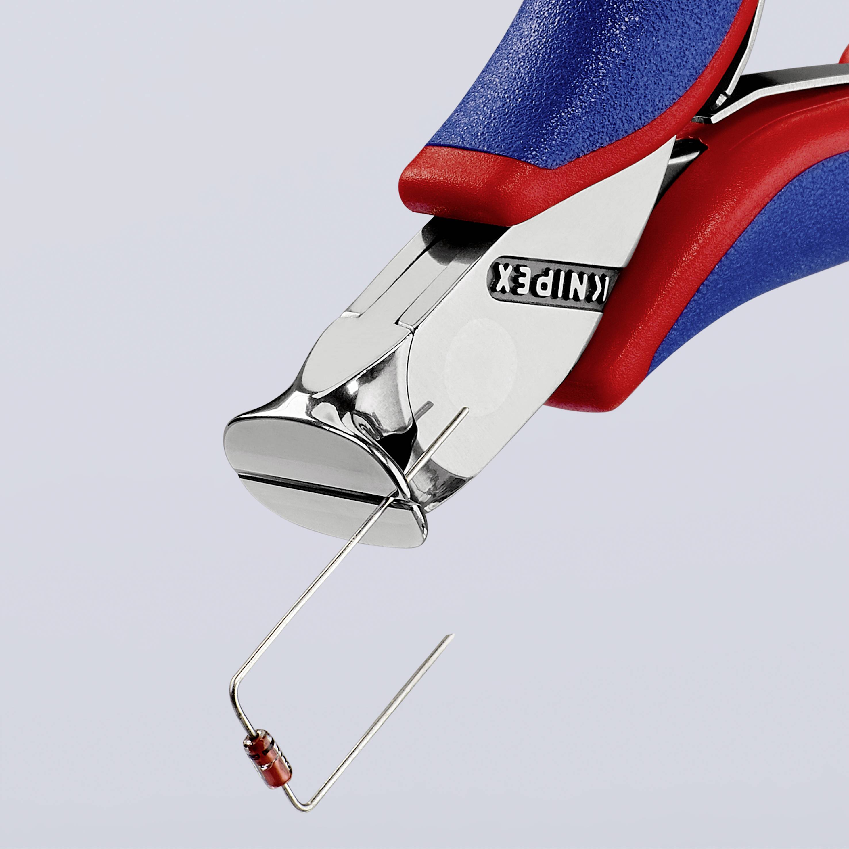 Kleště v detailním záběru s modro-červenou rukojetí a malým kovovým drátem mezi čelistmi.