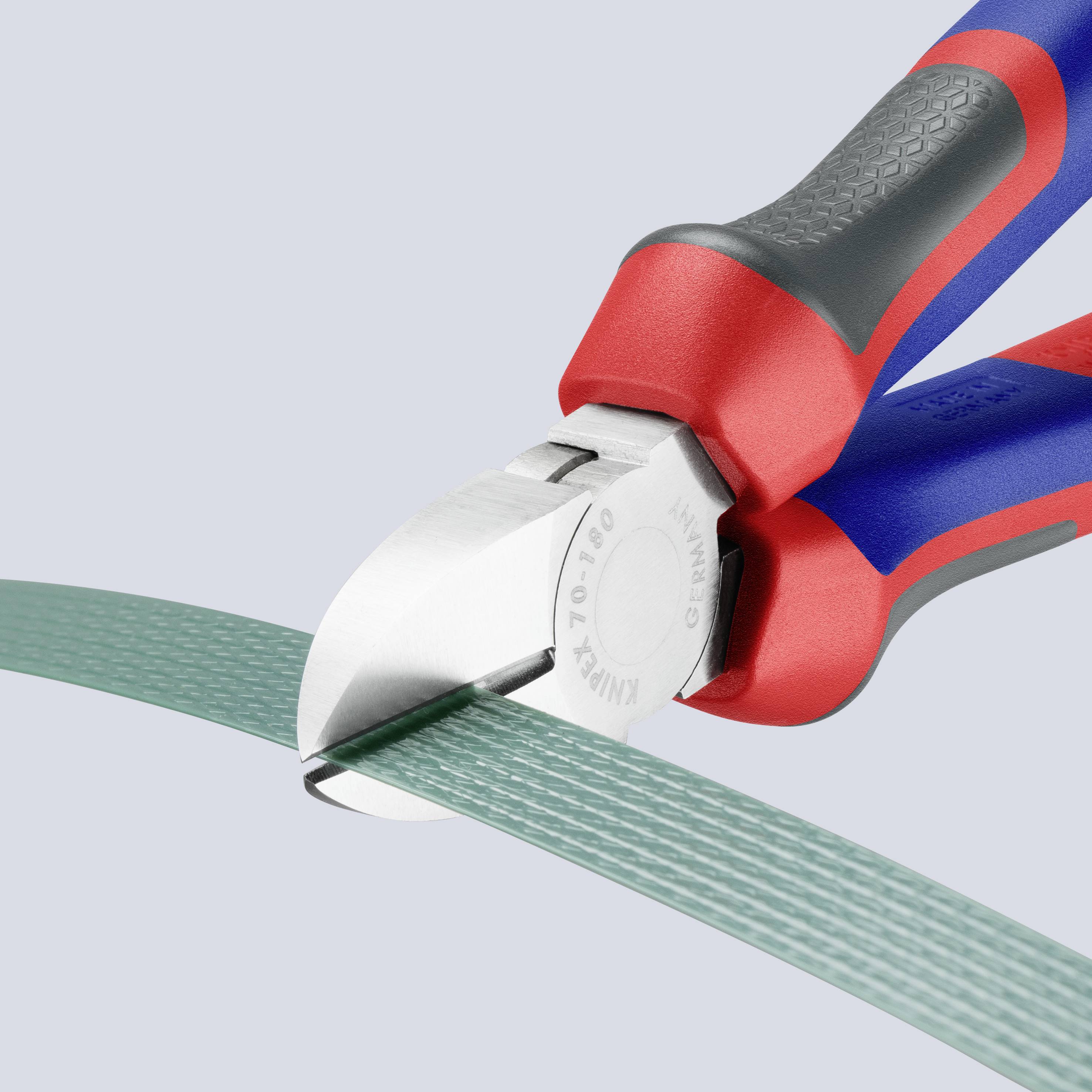 Kleště přestřihnou zelený kabel. Nástroj má červené a modré rukojeti a řeže precizními čelistmi.