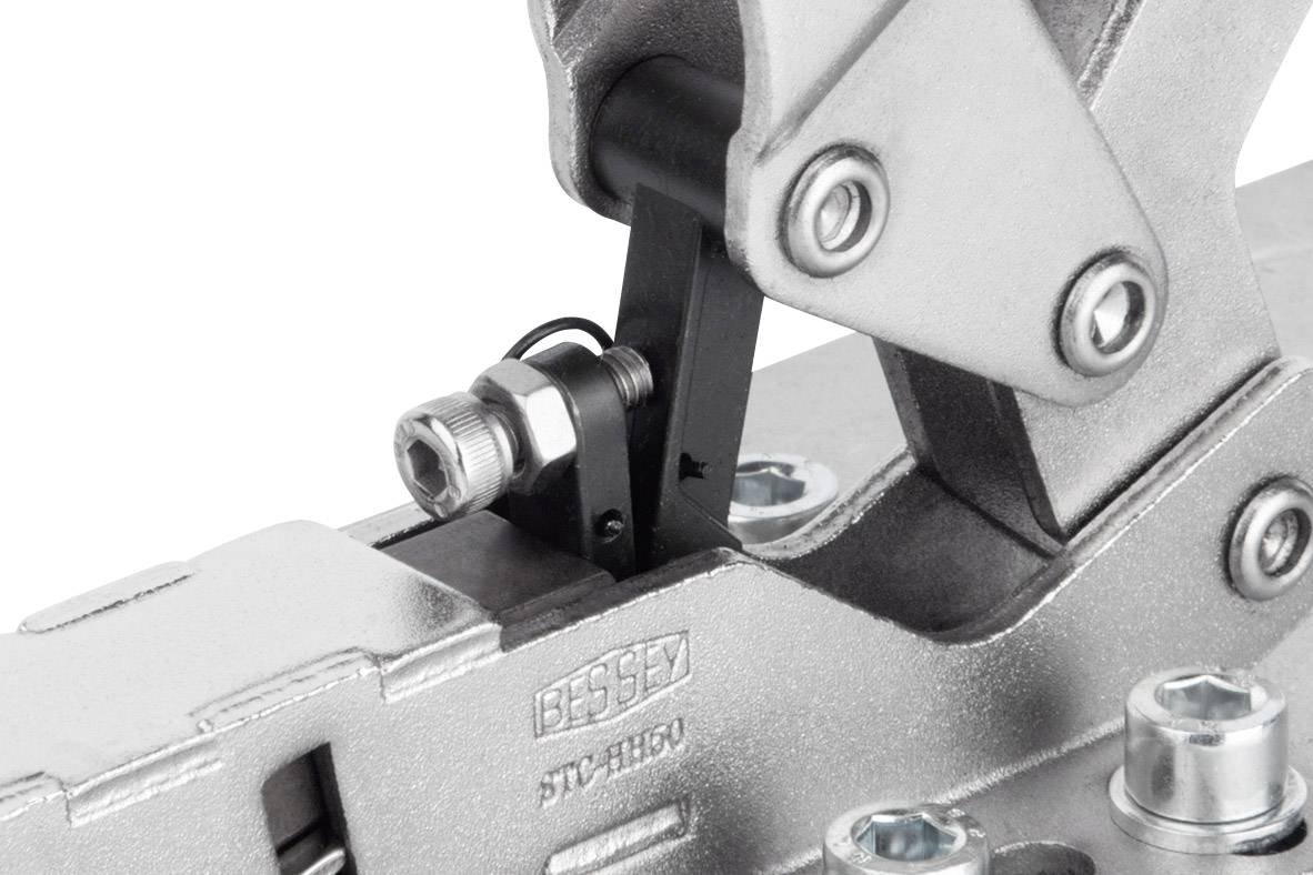 Průmyslový napínací nástroj z kovu s pákovým mechanismem, připevněný šrouby. Označený štítkem 'BESSEY STC-HH50'.