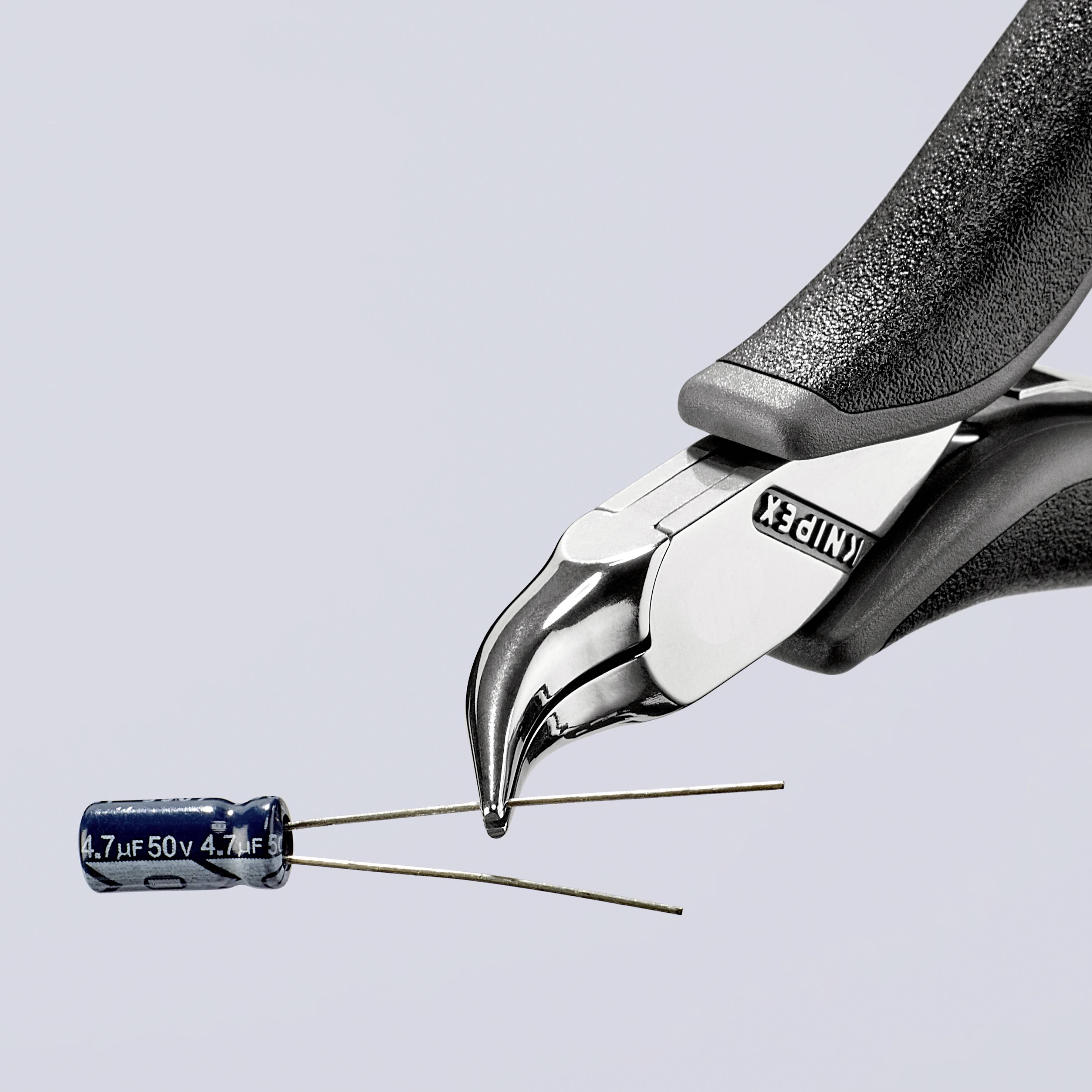 Boční štípací kleště ustřihnou dráty modrého elektrolytického kondenzátoru s nápisem '4,7µF 50V'.