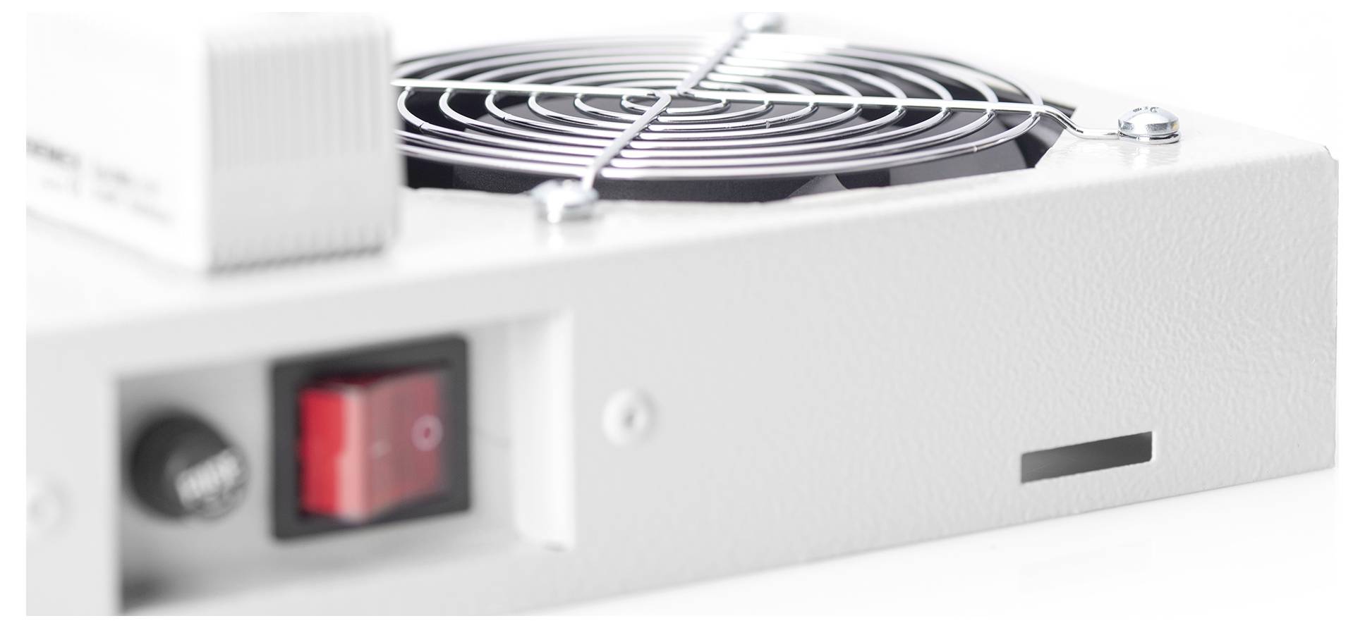 Detailný pohled na bílé elektrické zařízení s kulatým chladícím ventilátorem, červeným vypínačem zapnuto/vypnuto a malým větraným otvorem na jeho povrchu.