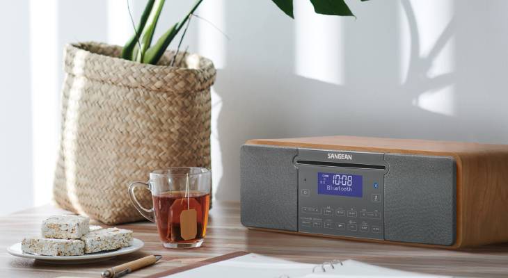 Stůl s šálkem čaje, košíkem a rádiem. Rádio ukazuje '10:08 Bluetooth'.