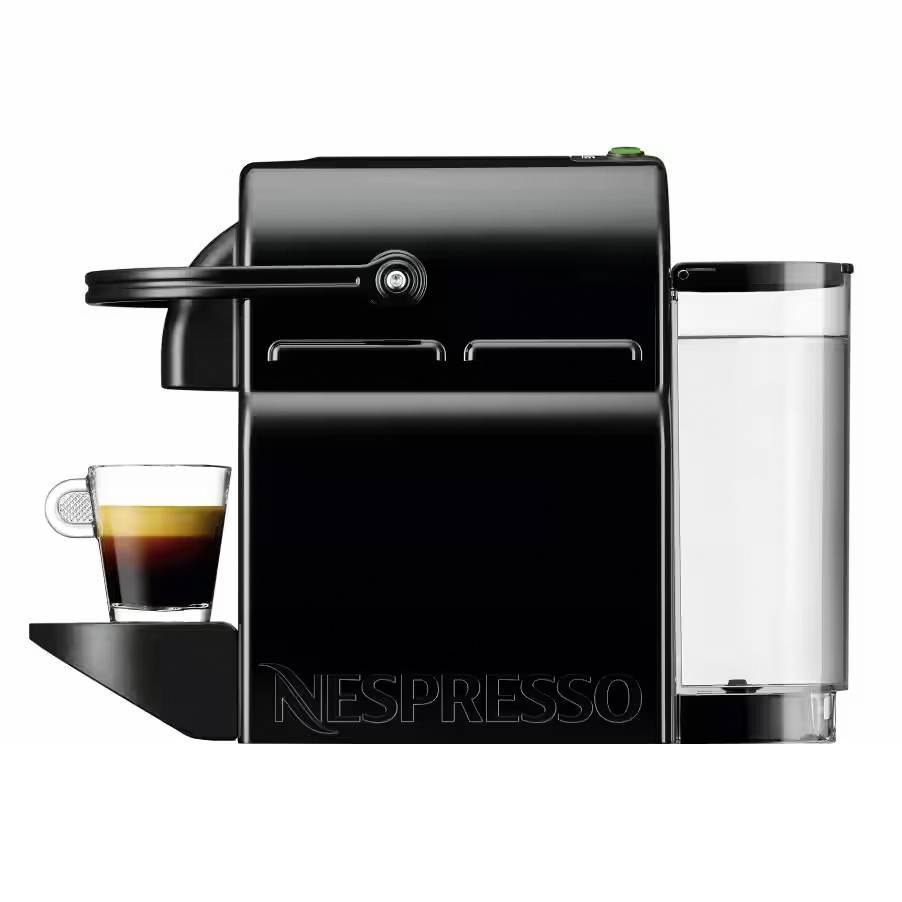 Černý Nespresso kávovar z boku s skleněným šálkem plným espressa, umístěný na odkapávací misce.