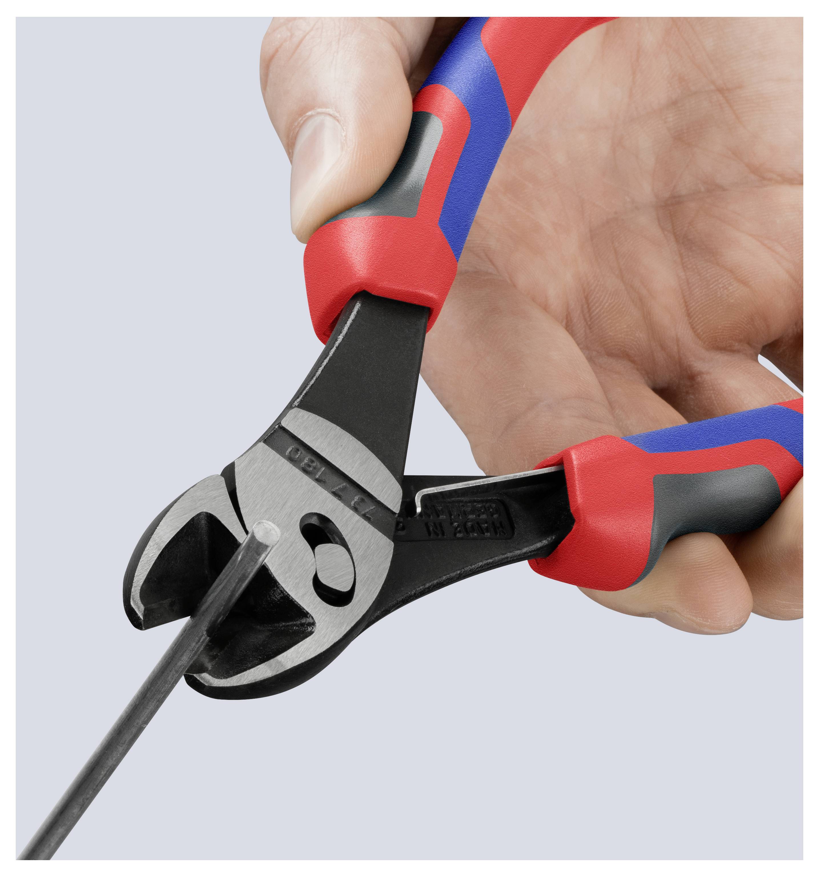 Ruka používá kleště s červenou a modrou rukojetí k přestřižení kovové tyče, což demonstruje schopnost nástroje krájet tvrdé materiály.