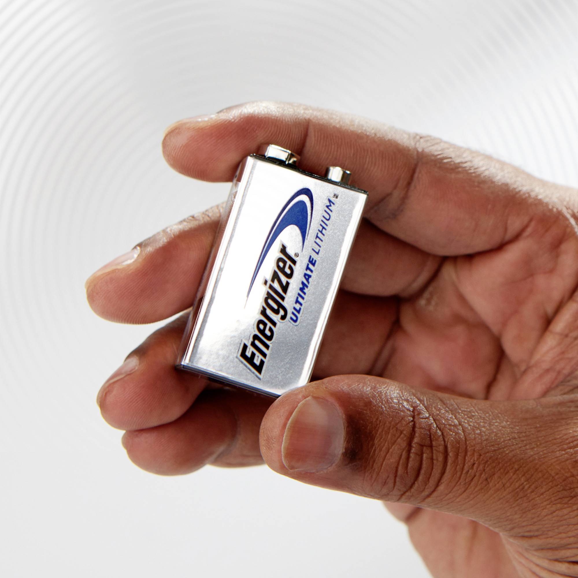 Jedna ruka drží stříbrnou baterii 'Energizer Ultimate Lithium'.