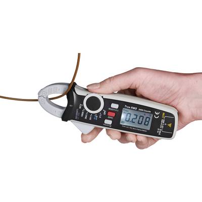 Jedna ruka drží digitální měřicí přístroj elektrického proudu, který zobrazuje hodnotu '0,208' a obepíná hnědý vodič.