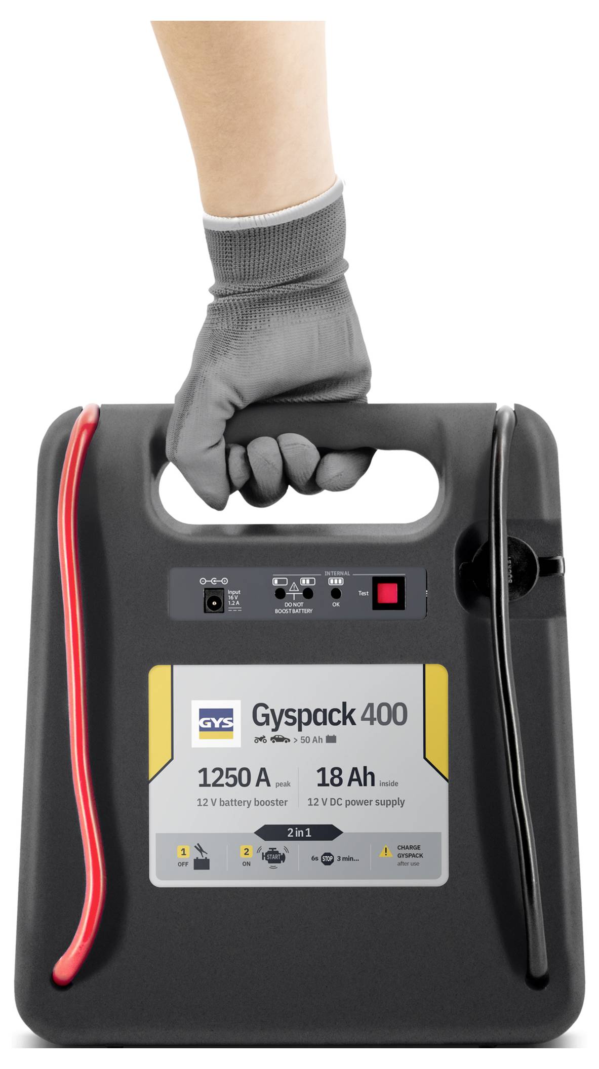 Rukavicemi oblečená ruka držící přenosný zážehovací startér GYS Gyspack 400, ukazující jeho přední panel, rukojeť a připojené červené a černé kabely.