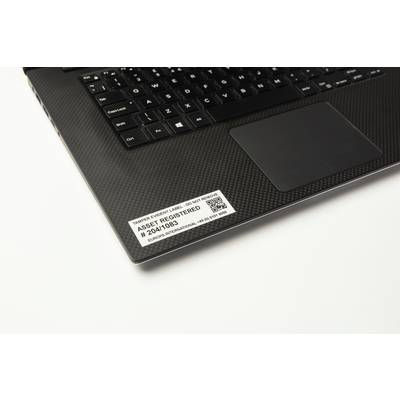 Notebook s černou klávesnicí zobrazuje štítek s nápisem 'Asset Registered' a sériovým číslem na opěrce zápěstí.