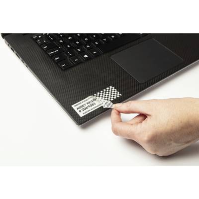 Jedna ruka odstraňuje bezpečnostní štítek z laptopu.