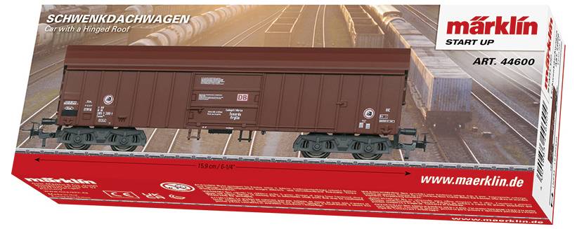 Krabice modelového vlaku zobrazující "Schwenkdachwagen - Vůz s otočnou střechou," Märklin Start Up, Art. 44600, v pozadí železniční scény.