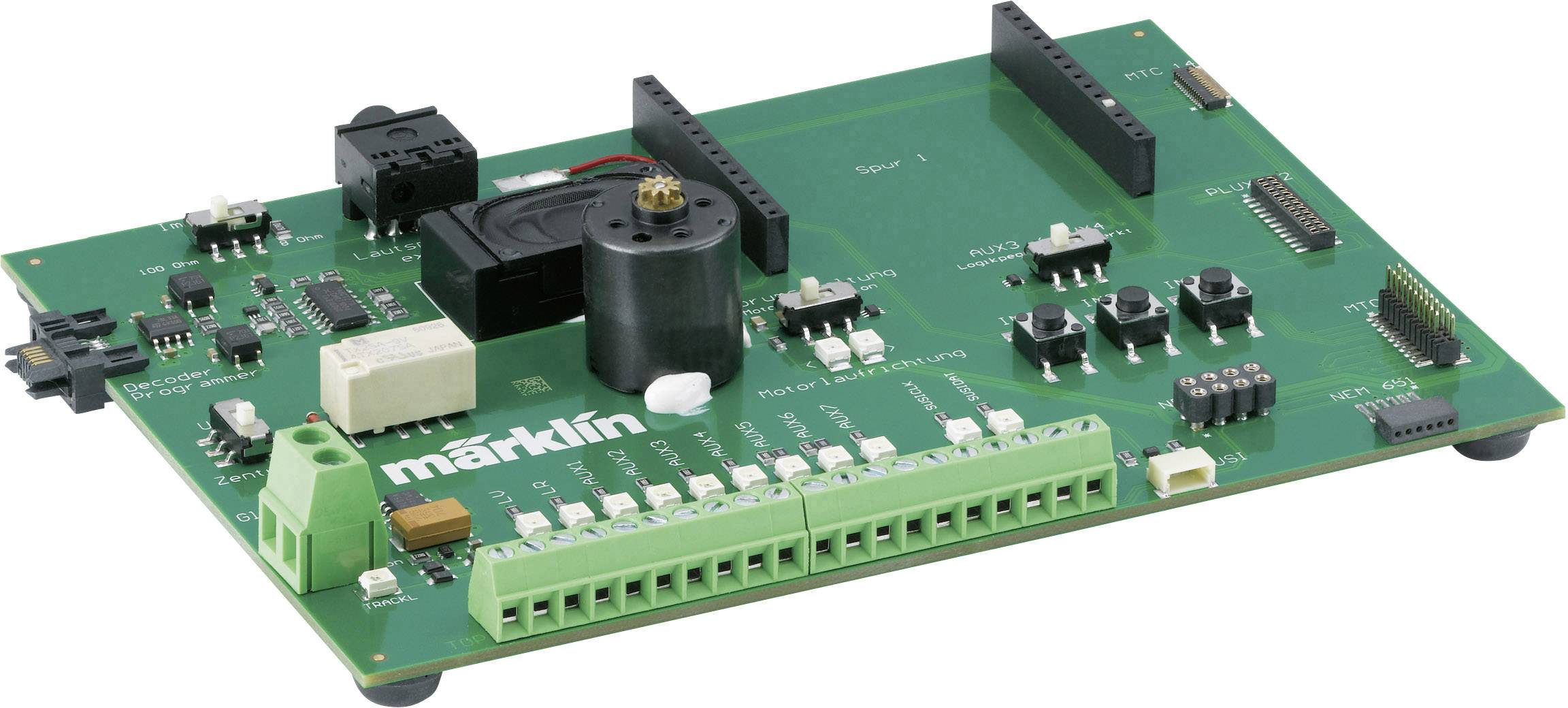 Zelená elektronická řídicí deska s komponenty a nápisem 'märklin'. Obsahuje elektrické obvody, konektory a přepínače.