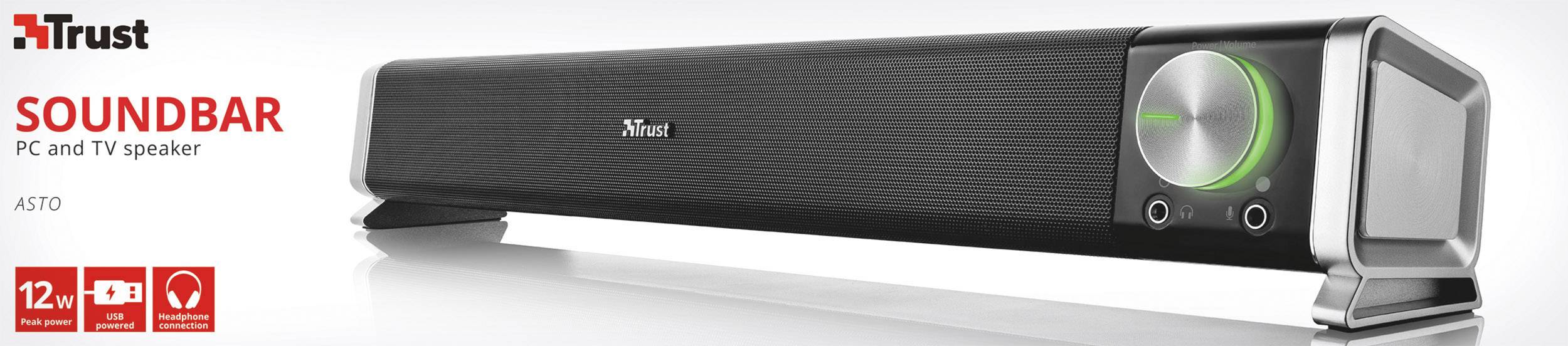 Černý soundbar značky Trust s regulátorem hlasitosti a zeleným LED osvětlením, vhodný pro PC a TV. Vlevo na obrázku: "SOUNDBAR, reproduktor pro PC a TV".