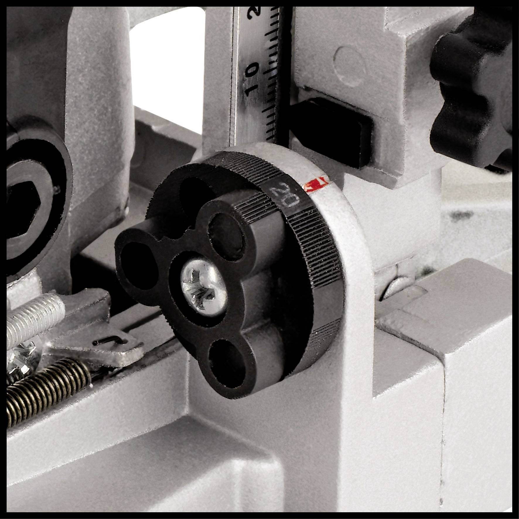 Detailní pohled na stroj s měřicí stupnicí a otočným knoflíkem; zobrazuje přesné mechanické díly pro jemné seřízení.