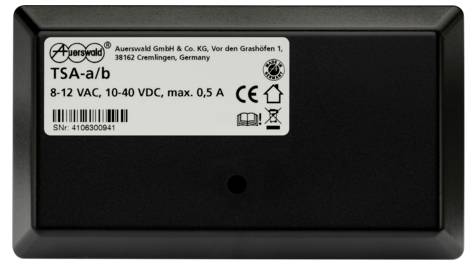 Černé zařízení s nálepkou: 'Auerswald GmbH & Co. KG', 'TSA-a/b', '8-12 VAC, 10-40 VDC, max. 0,5 A', sériové číslo.