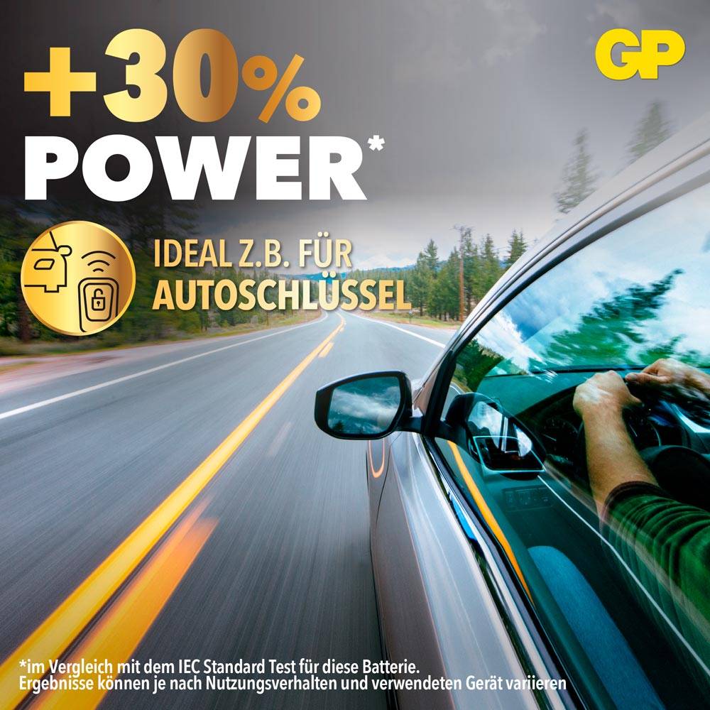 Reklama na baterie: +30% energie, ideální např. pro autoklíče. Obrázek ukazuje auto na silnici s jasnou oblohou.