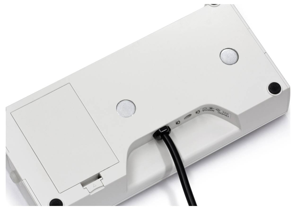 Bílá elektronická váha pohledem zdola, zobrazující černý kabel, prostor pro baterie a gumové protiskluzové nožičky pro stabilitu.