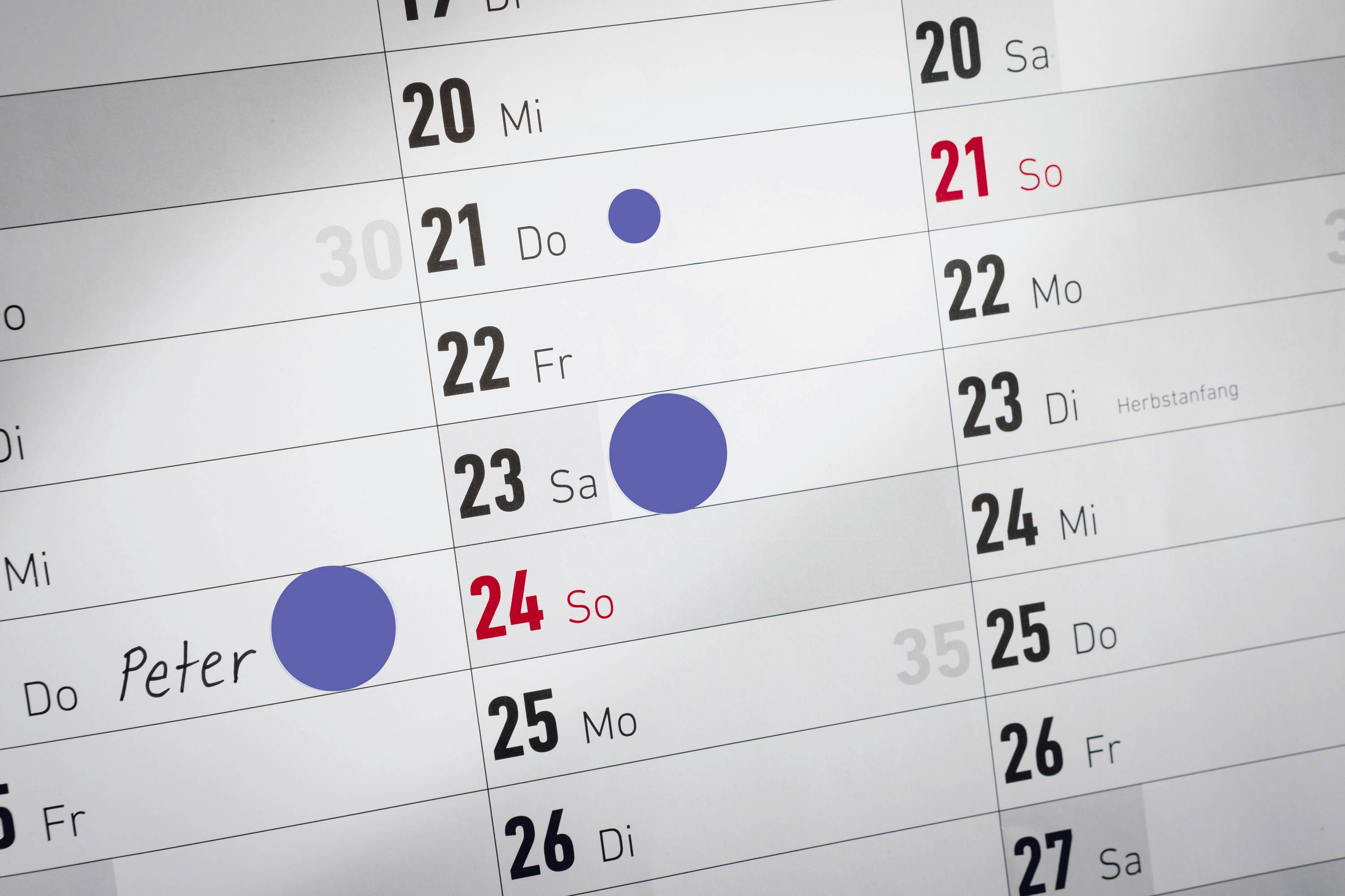 Kalendář ukazuje dny od 20. do 25. se modrými značkami 22. a 23. a nápisem 'Peter' dne 24.