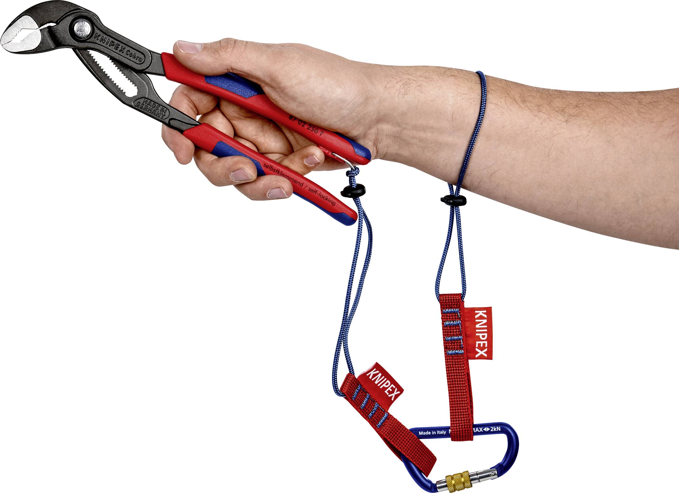 Ruka drží kleště KNIPEX s bezpečnostním lanem a karabinou.