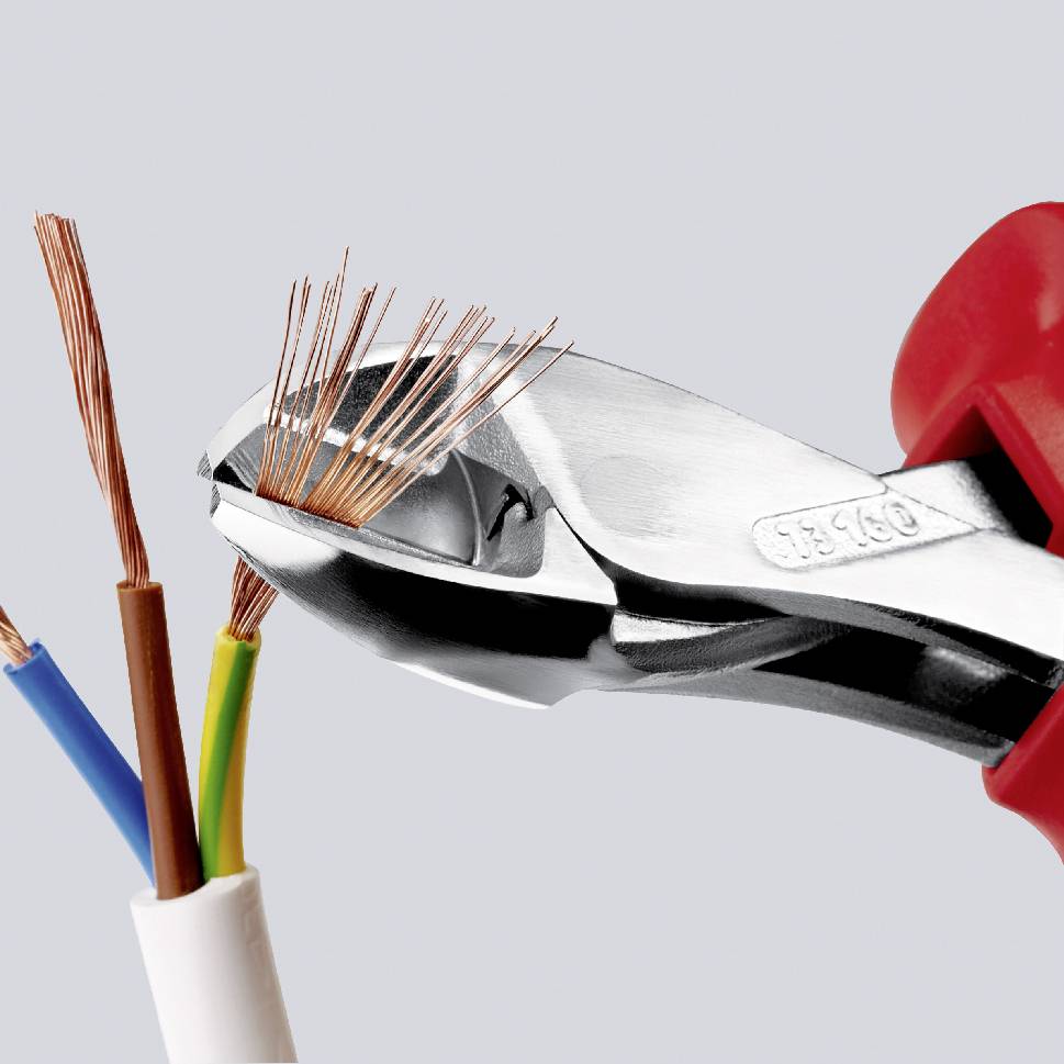 Štípací kleště přestřihnou kabel a odhalí měděné vodiče, ukazují nástroj při elektrotechnické práci.
