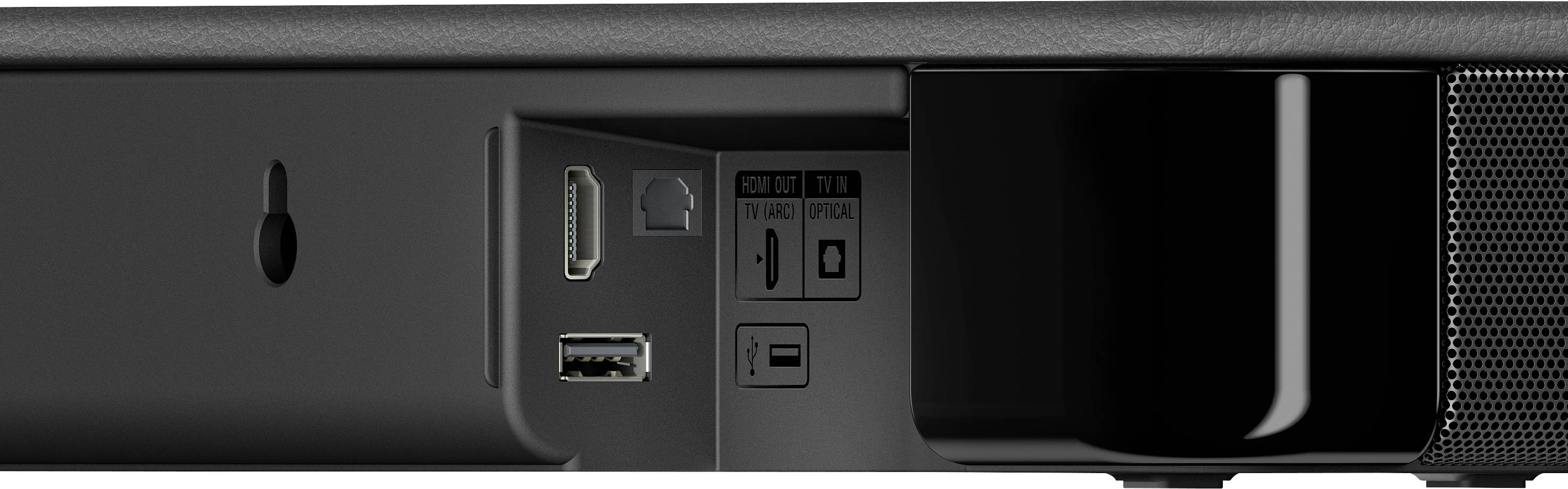 Zadní strana elektronického zařízení s různými porty: HDMI, USB a optický. Vlevo se nachází otvor pro nástěnné upevnění.