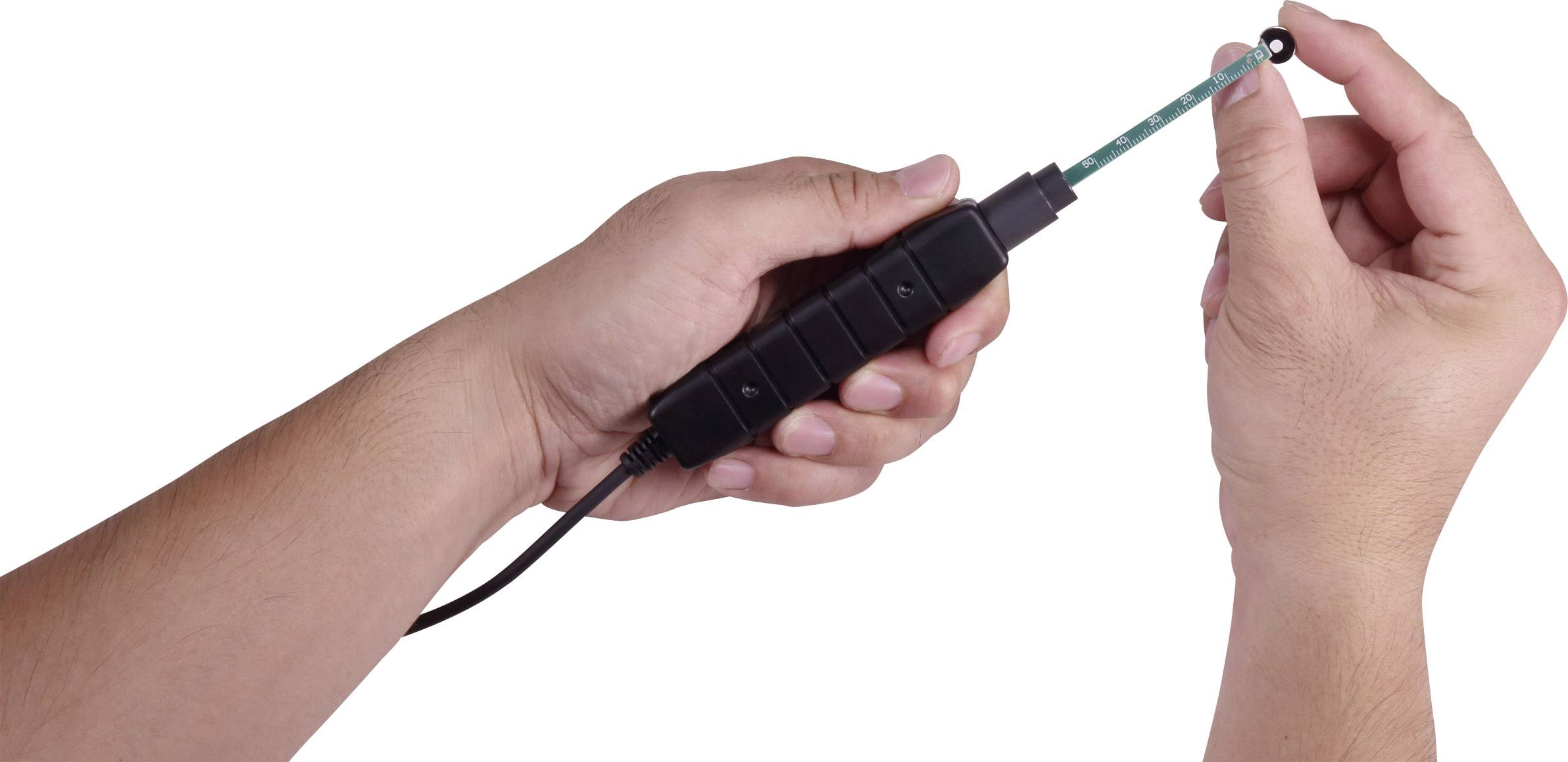 Osoba drží elektronické testovací zařízení s dlouhou sondou, které pravděpodobně slouží k měření kapalin nebo jiných látek.