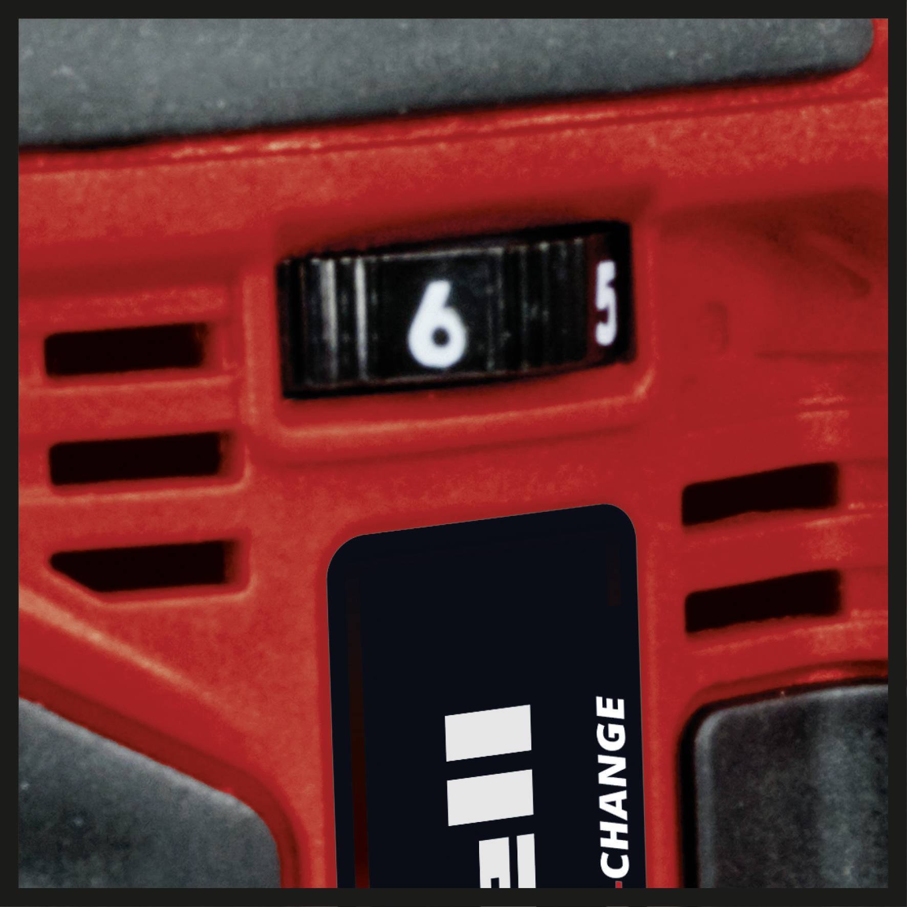 Detailní záběr červeného elektrického nástroje s černým, očíslovaným nastavovacím kolečkem na horní straně, které ukazuje na '6'.