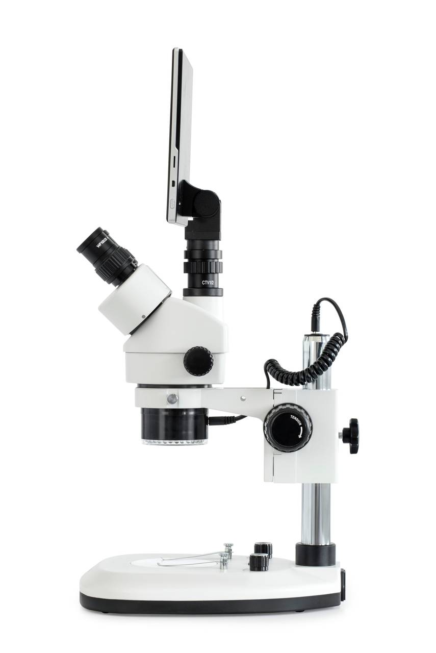 Bílý laboratorní mikroskop s digitálním displejem, pohled z boku. Hlavní využití ve vědeckém výzkumu a analýze.