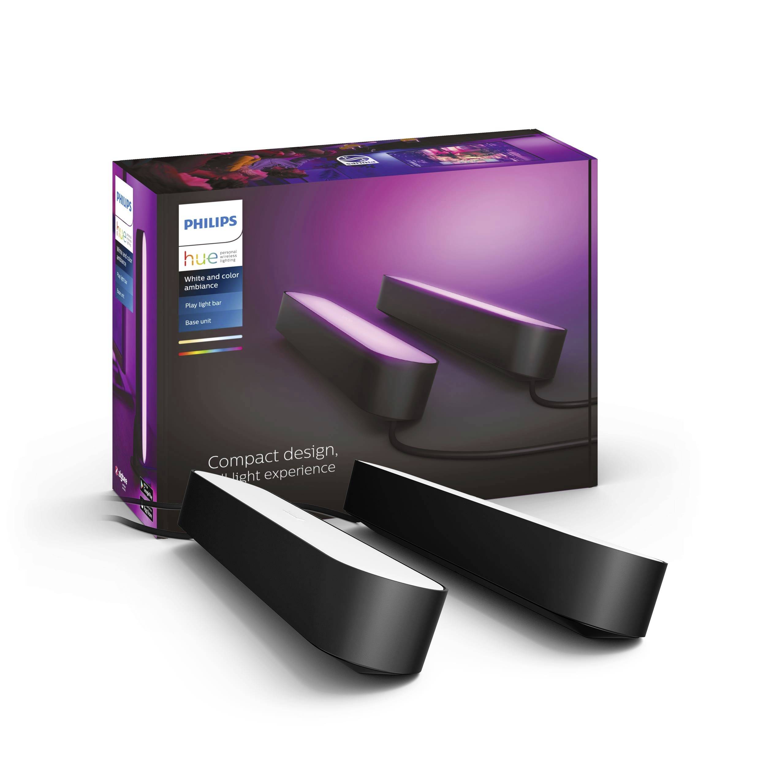 Dva světelné pásy Philips Hue Play před obaly produktu. Svítidla jsou černá a vyzařují fialové světlo.