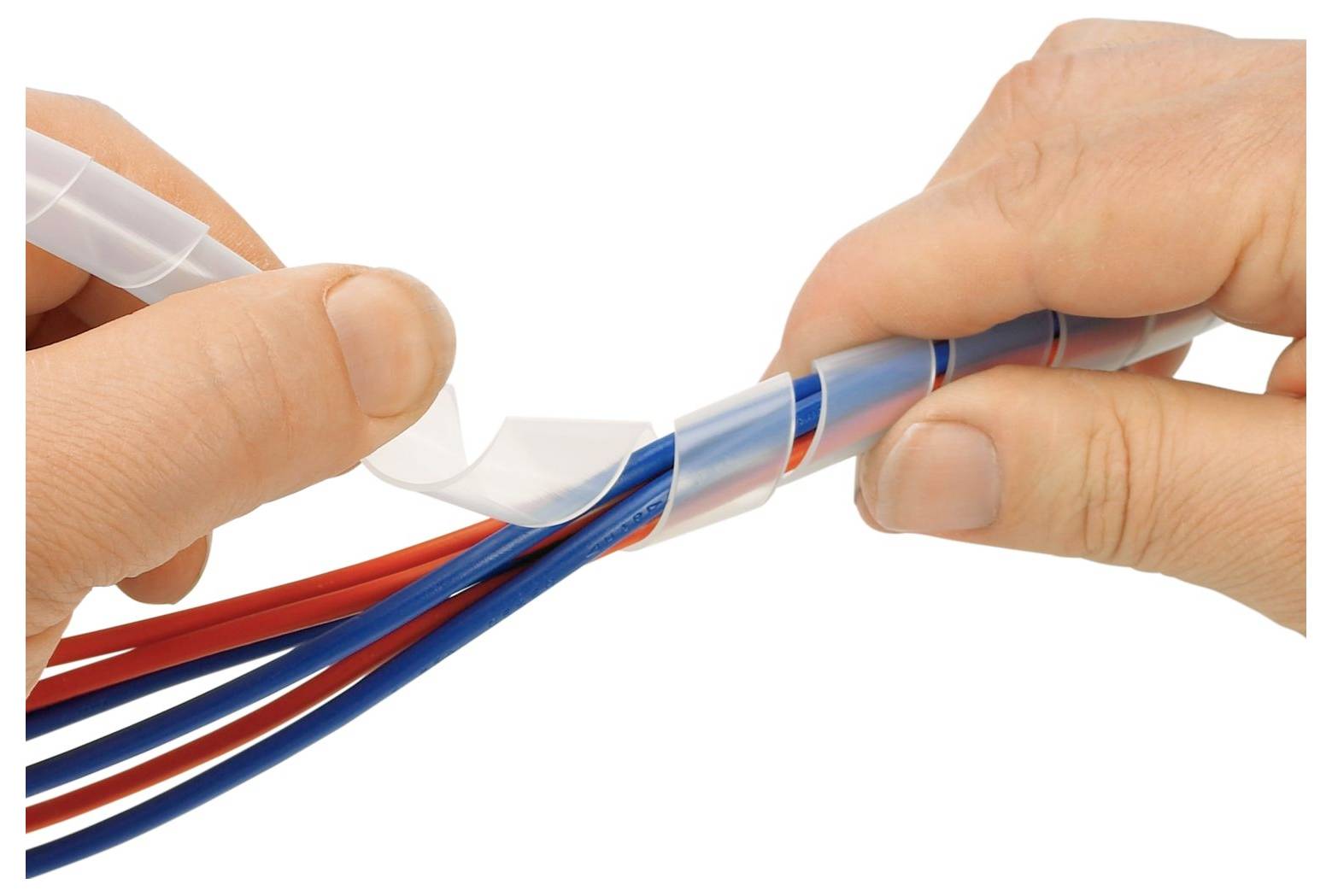 Ruce балují skupinu červených a modrých elektrických kabelů průsvitnou spirálovou vázací páskou, aby je organizovaly a chránily.