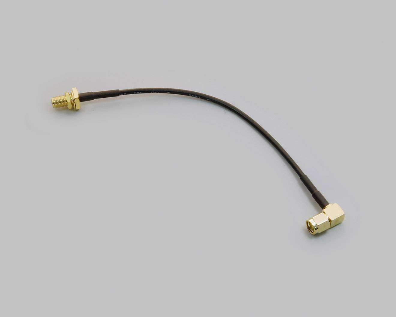 Krátký koaxiální kabel s přímou a lomovou SMA konektorovou koncovkou. Ideální pro rádiové aplikace a anténní připojení.