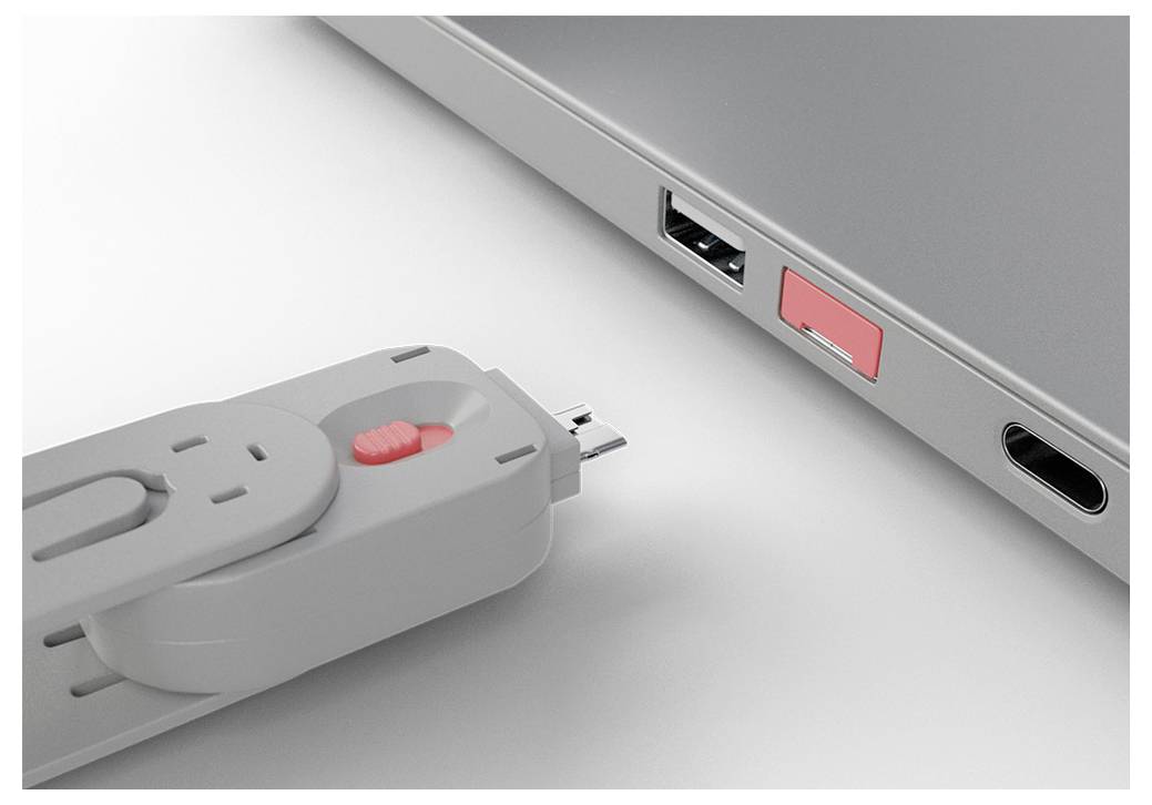 USB flash disk vkládaný do USB portu notebooku vedle dalšího obsazeného portu.