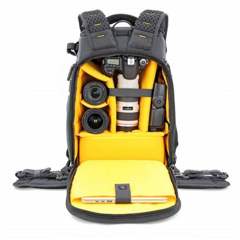 Otevřený černý batoh odhaluje fotografickou výbavu: fotoaparát, dva objektivy a laptop v polstrovaných žlutých přihrádkách.