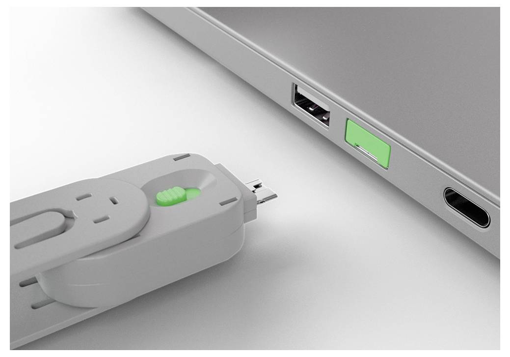 Zblízka pohled na USB disk připojovaný do USB portu notebooku vedle dalšího portu a zeleného indikátoru.
