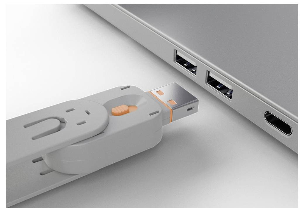 Detailní záběr na USB-C konektor vkládaný do USB-C portu notebooku s dvěma USB-A porty v blízkosti.