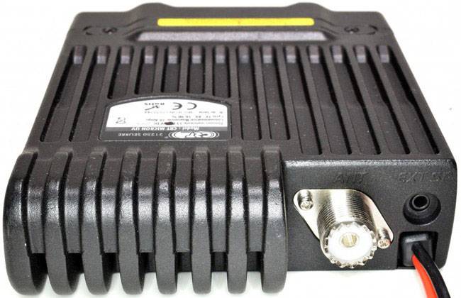 Obrázek ukazuje černé elektronické zařízení s chladicími žebry a konektory na přední straně, používané pro komunikaci.