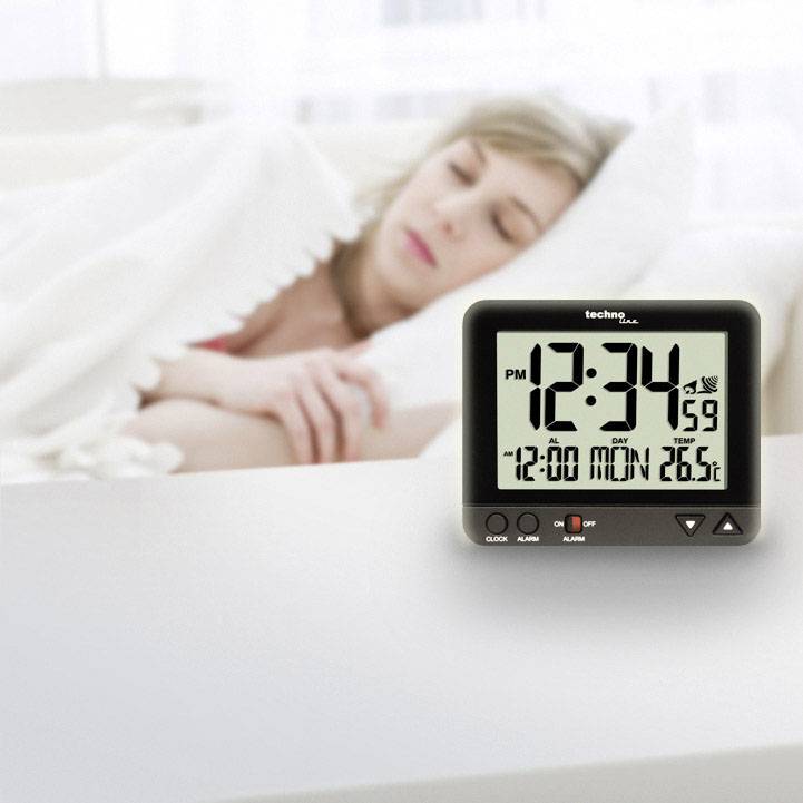 Žena spí; v popředí digitální hodiny ukazují '12:00', 26 % vlhkosti a 15,9 °C.