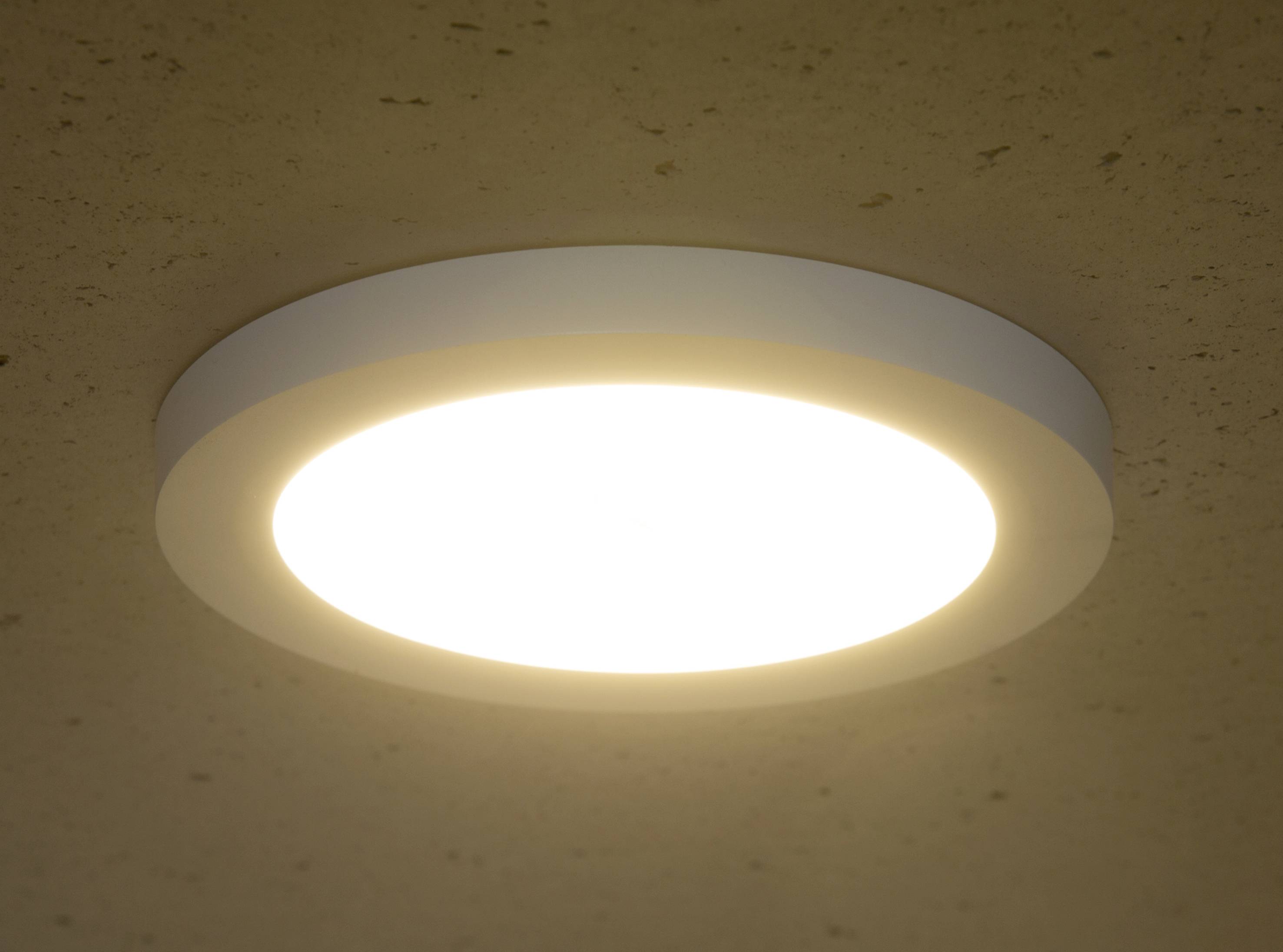 Na stropě je namontována světlá, kulatá stropní lampa, která zajišťuje rovnoměrné osvětlení.